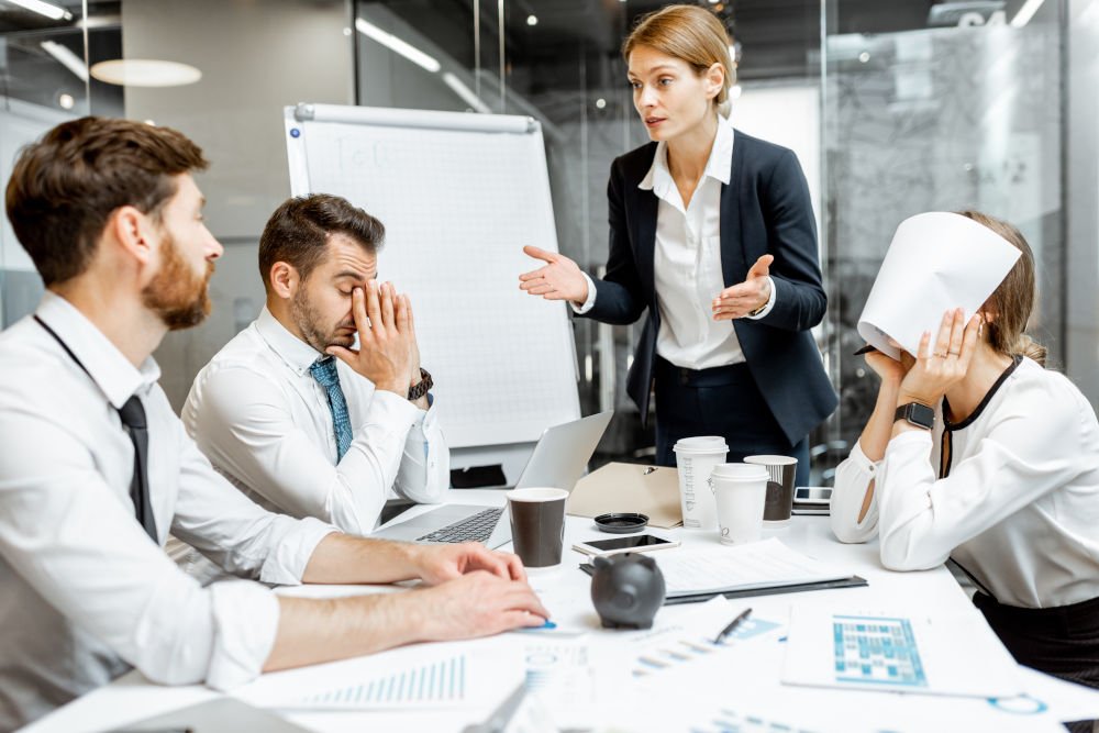 boss quarreling at employees during a conference