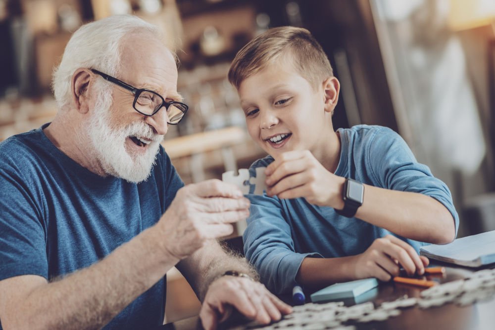 happy mature man holding puzzle in right hand